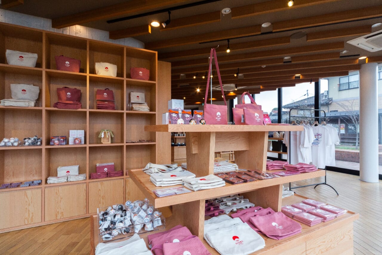 落ち着いたピンクが特徴で縁結びがテーマの“BEAMS JAPAN IZUMO”のロゴ入りランチトートや「出雲縁結びだるま」が並ぶ店内